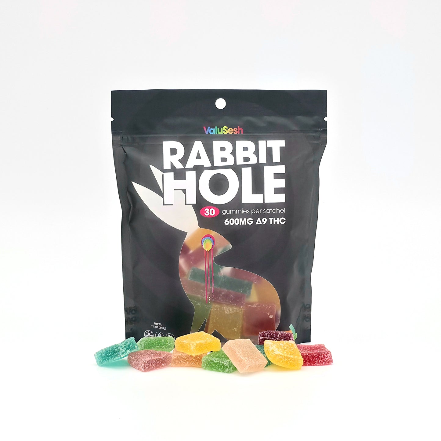 A black stand-up pouch of ValuSesh Rabbit Hole gummies with several colorful gummy candies scattered in front on a clean white background.